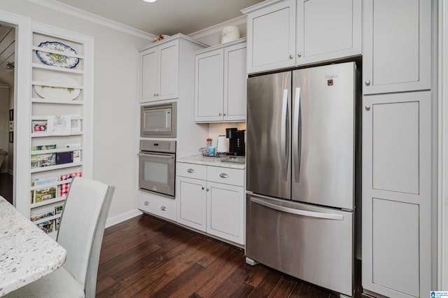 kitchen with dark wood-type flooring, crown molding, light stone countertops, appliances with stainless steel finishes, and white cabinetry