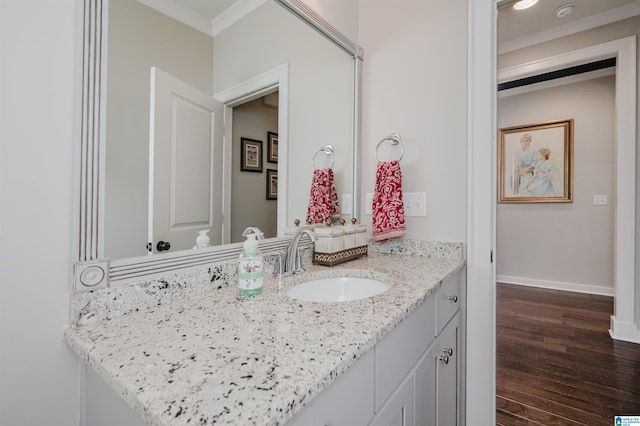 bathroom with crown molding, hardwood / wood-style floors, and vanity