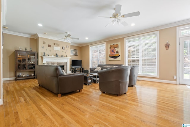 living room featuring a brick fireplace, ceiling fan, and light wood-type flooring