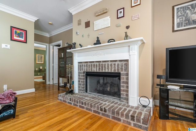 living room featuring hardwood / wood-style flooring, a brick fireplace, and crown molding