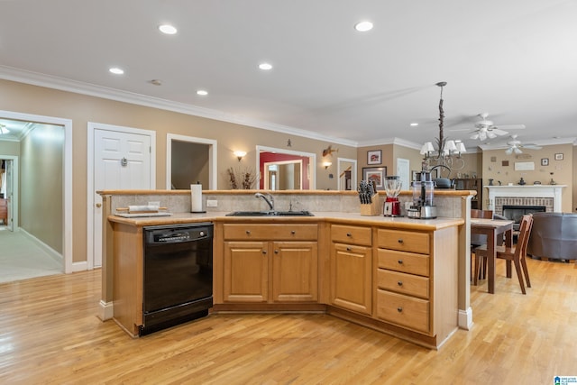 kitchen featuring dishwasher, a kitchen island with sink, sink, light wood-type flooring, and a fireplace