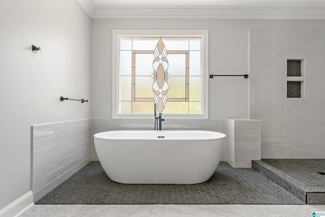 bathroom featuring tile patterned flooring, ornamental molding, a tub to relax in, and tile walls