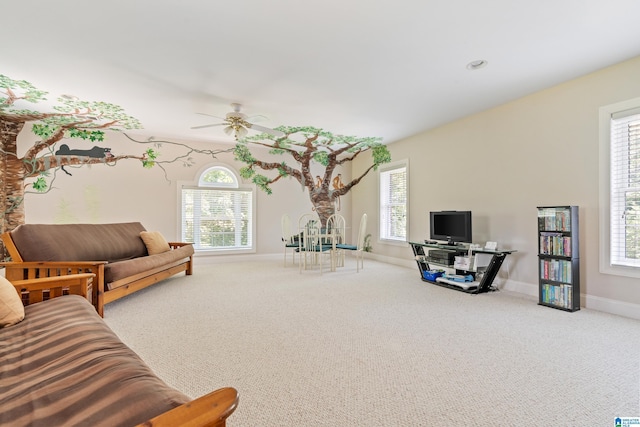 carpeted living room with ceiling fan and plenty of natural light