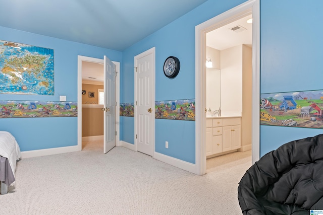 bedroom featuring ornamental molding, light carpet, and ensuite bath