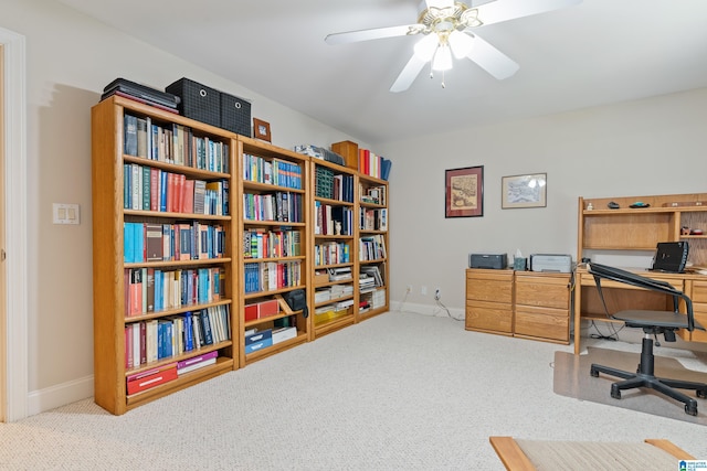 carpeted home office featuring ceiling fan