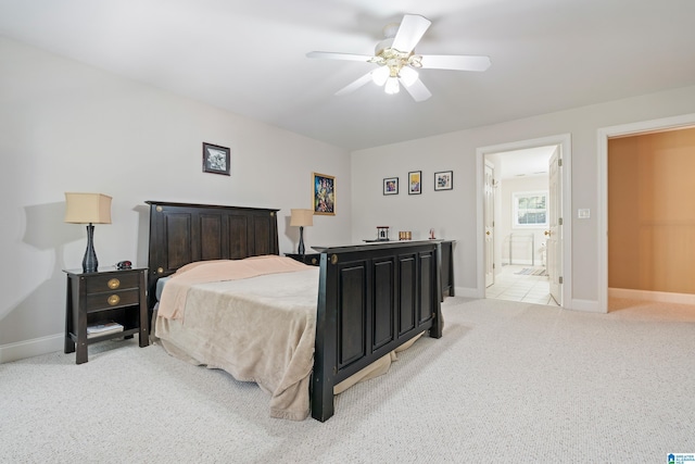 bedroom featuring connected bathroom, ceiling fan, and light colored carpet