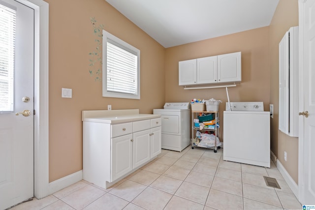 laundry area featuring cabinets, independent washer and dryer, and light tile patterned floors