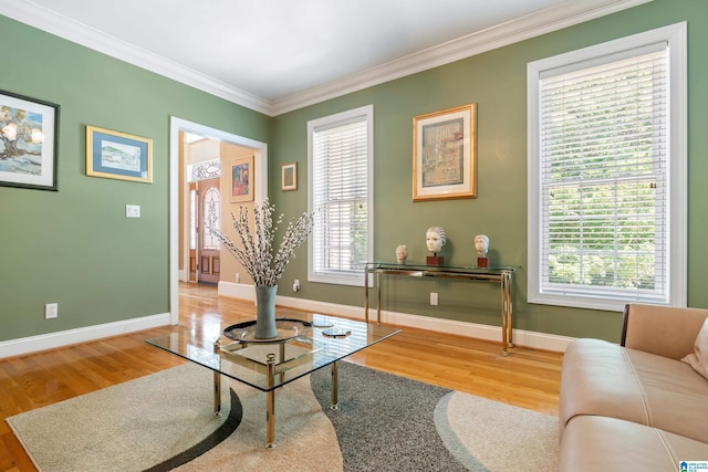 sitting room featuring a healthy amount of sunlight, wood-type flooring, and crown molding