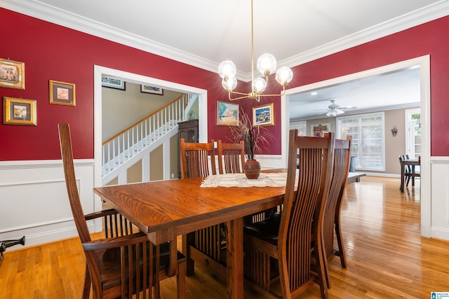 dining room featuring crown molding, wood-type flooring, and ceiling fan with notable chandelier