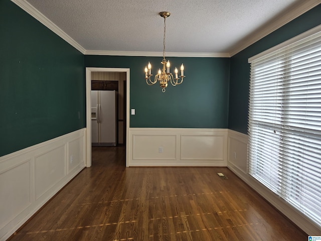 interior space featuring a textured ceiling, an inviting chandelier, and crown molding