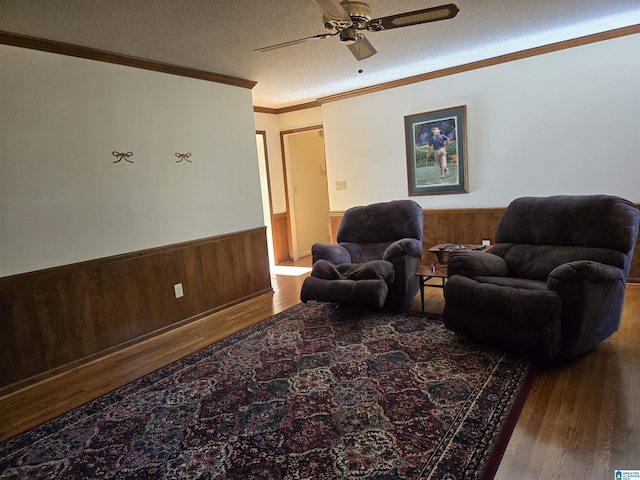 living room featuring hardwood / wood-style floors, a textured ceiling, ceiling fan, and ornamental molding