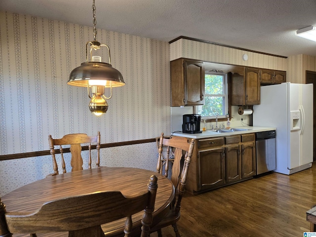 kitchen with dishwasher, sink, dark hardwood / wood-style floors, a textured ceiling, and decorative light fixtures