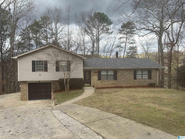 tri-level home featuring a garage and a front lawn