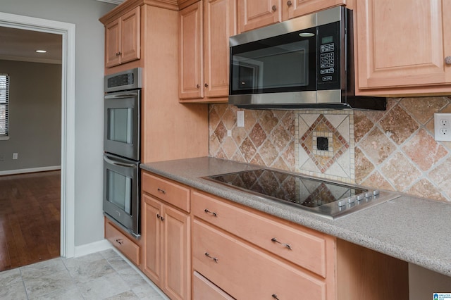 kitchen with backsplash, crown molding, and appliances with stainless steel finishes