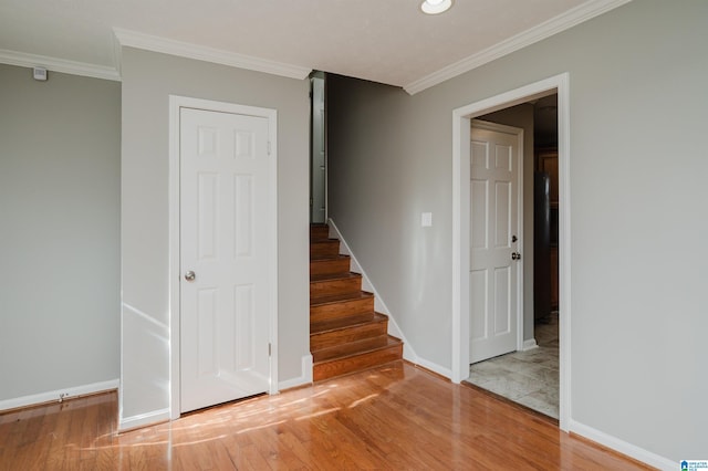 staircase with hardwood / wood-style flooring and ornamental molding