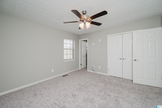 unfurnished bedroom featuring ceiling fan, a closet, carpet, and a textured ceiling