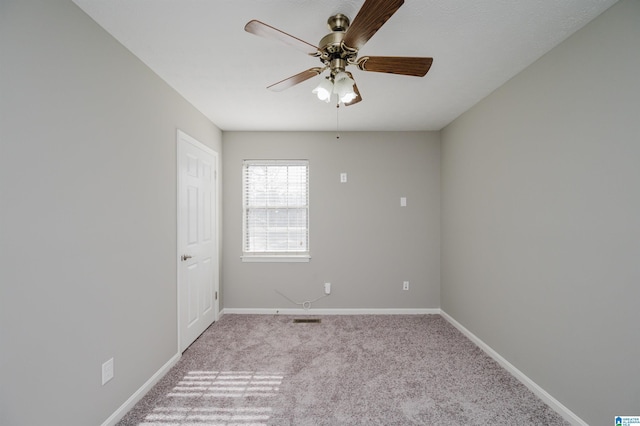 spare room with ceiling fan and light colored carpet