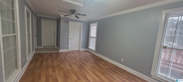 unfurnished bedroom with wood-type flooring, a textured ceiling, ceiling fan, and crown molding