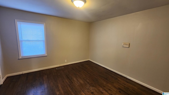 spare room with dark hardwood / wood-style floors