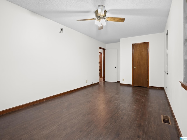 spare room featuring ceiling fan, dark hardwood / wood-style flooring, and a textured ceiling