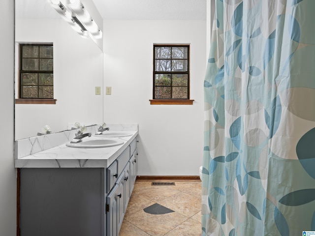 bathroom with a textured ceiling, vanity, and curtained shower