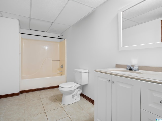 full bathroom with a drop ceiling, vanity,  shower combination, tile patterned flooring, and toilet