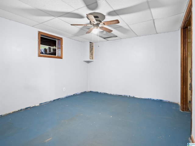 basement with a paneled ceiling and ceiling fan