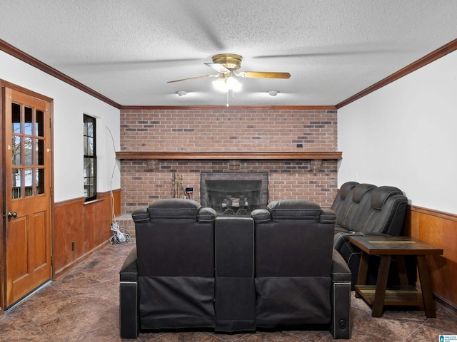 living room featuring ceiling fan, wood walls, crown molding, and a textured ceiling