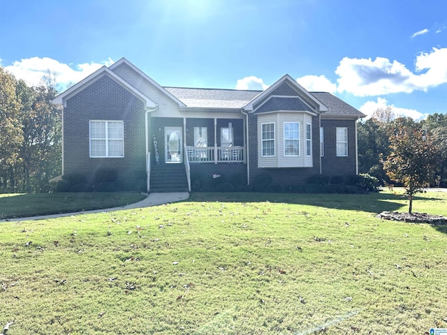 ranch-style house featuring covered porch and a front lawn