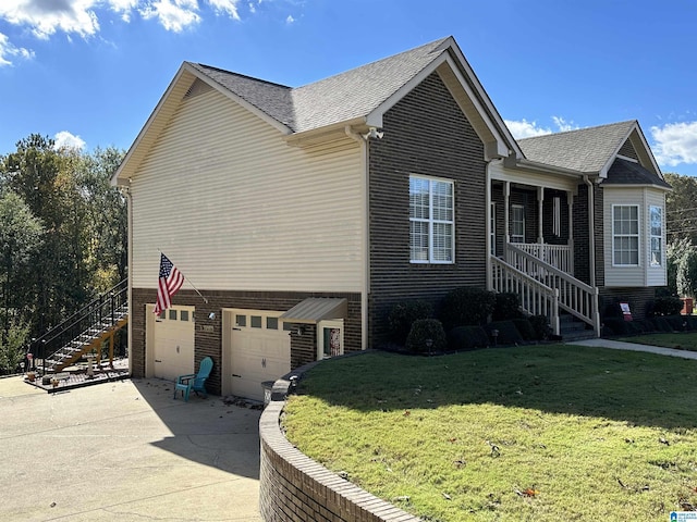 view of side of property with a lawn, covered porch, and a garage