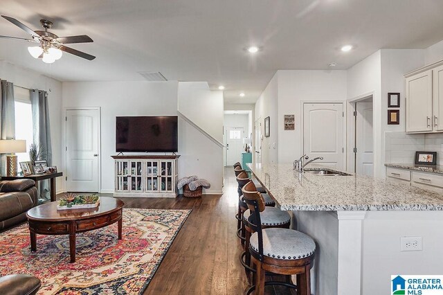 living room with ceiling fan, dark hardwood / wood-style flooring, and sink