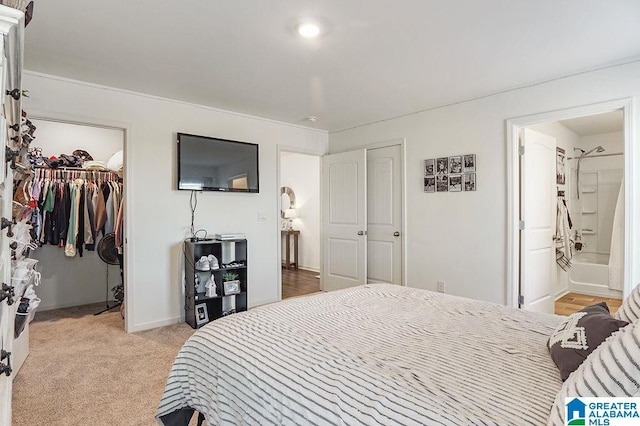 bedroom featuring light carpet and connected bathroom