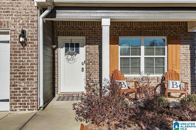 view of exterior entry featuring covered porch