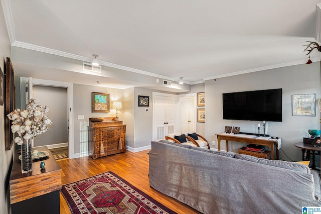 living room with light wood-type flooring and ornamental molding