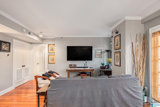 living room with light hardwood / wood-style floors and crown molding