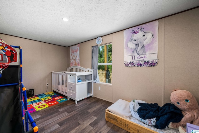 bedroom with dark hardwood / wood-style floors and a textured ceiling