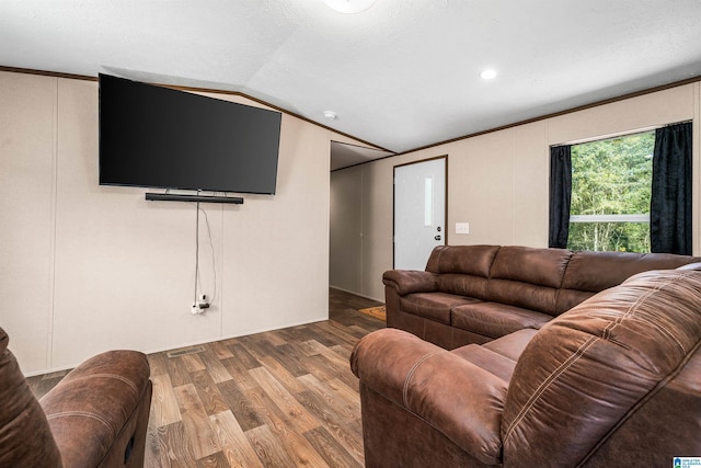 living room with hardwood / wood-style flooring, vaulted ceiling, and crown molding