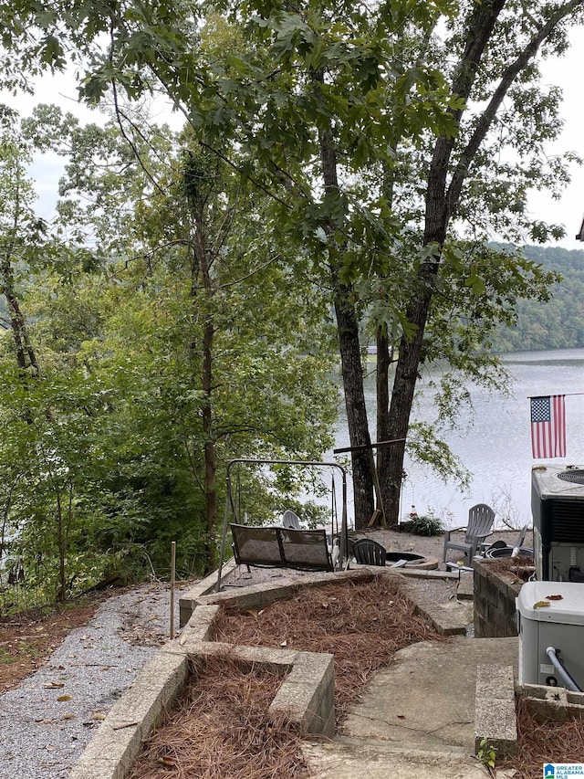 view of yard with a water view and central air condition unit