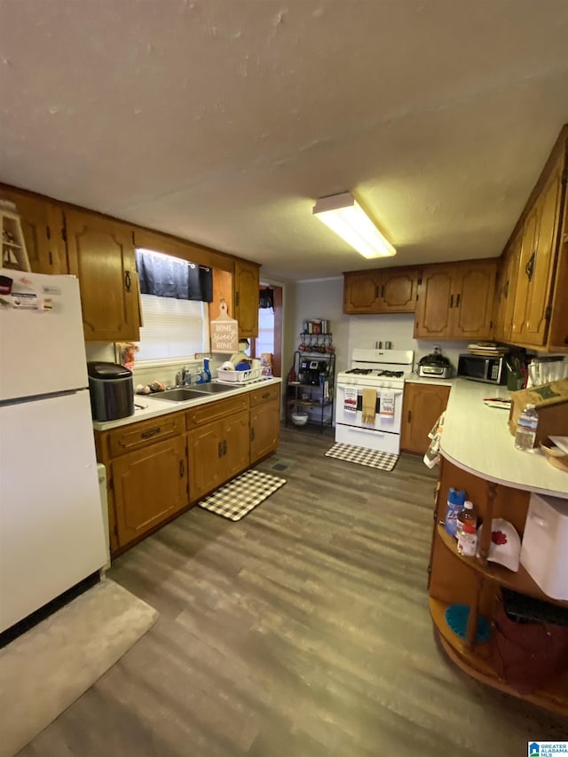 kitchen featuring sink, dark hardwood / wood-style floors, and white appliances