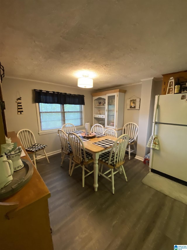 dining space featuring crown molding, dark hardwood / wood-style floors, and a textured ceiling