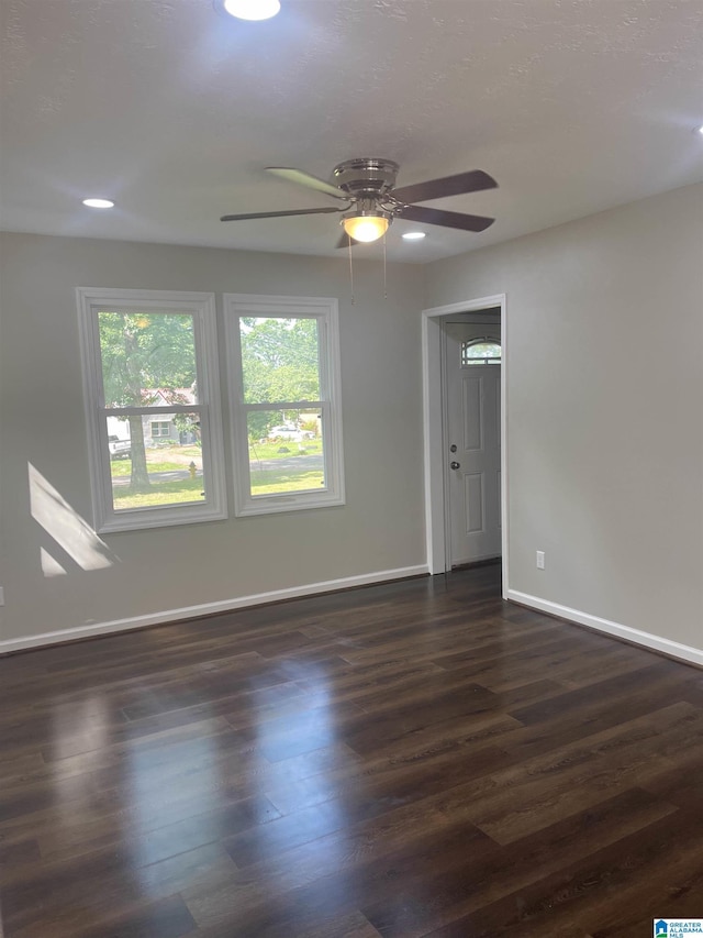 unfurnished room featuring ceiling fan and dark hardwood / wood-style flooring