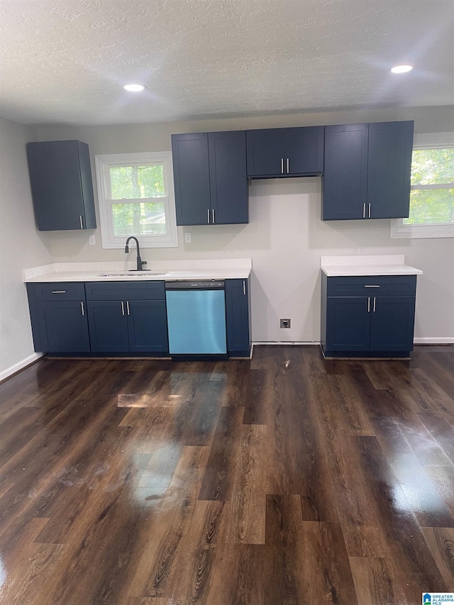 kitchen featuring blue cabinetry, dishwasher, sink, plenty of natural light, and a textured ceiling