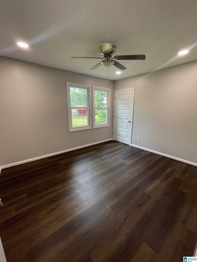 unfurnished room featuring ceiling fan and dark wood-type flooring