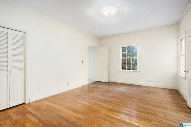 unfurnished bedroom with light hardwood / wood-style flooring and a closet