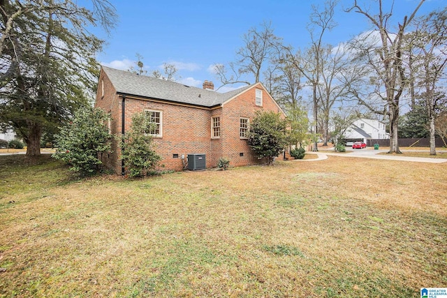 view of side of property with a yard and central air condition unit