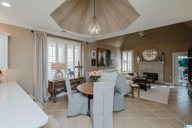 dining room featuring lofted ceiling, plenty of natural light, light tile patterned flooring, and ceiling fan with notable chandelier