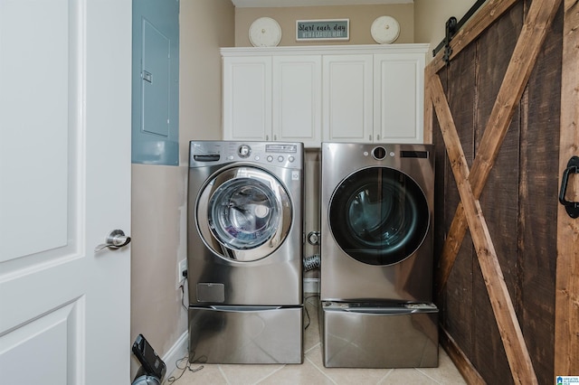 washroom featuring cabinets, a barn door, electric panel, light tile patterned floors, and washer and dryer