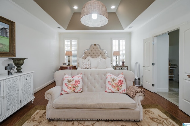 bedroom with hardwood / wood-style floors, multiple windows, and a tray ceiling