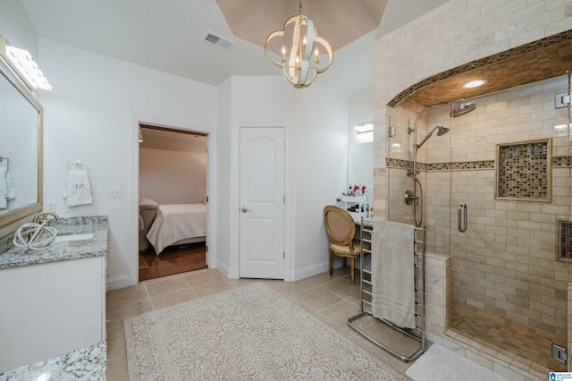 bathroom featuring tile patterned floors, vanity, a chandelier, and a shower with shower door