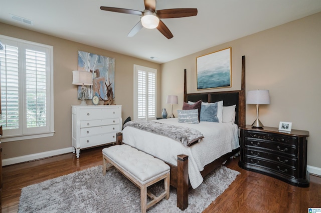 bedroom with multiple windows, ceiling fan, and dark wood-type flooring